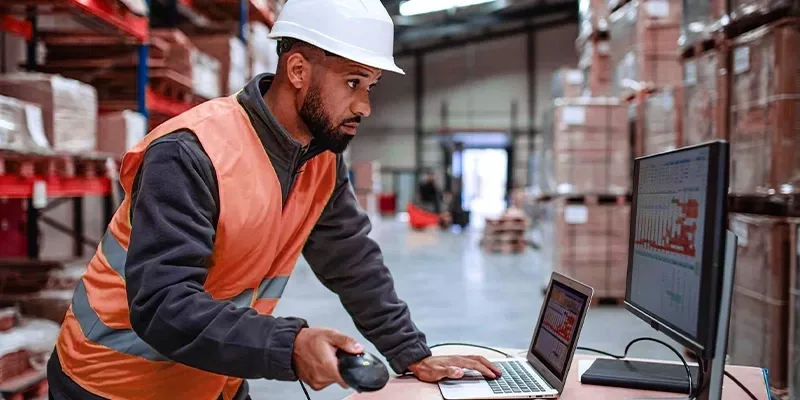 Warehouse worker using inventory management software to improve efficiency through lean warehousing